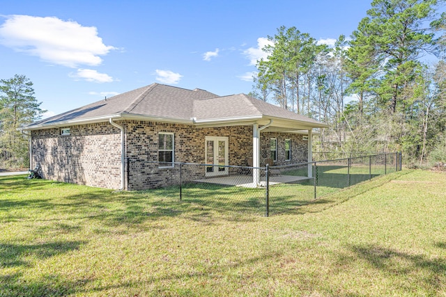 back of property with a yard, a patio, brick siding, and a fenced backyard