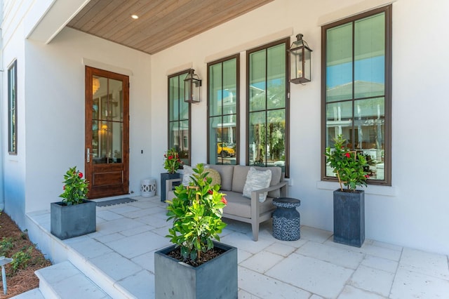 doorway to property featuring stucco siding and a porch