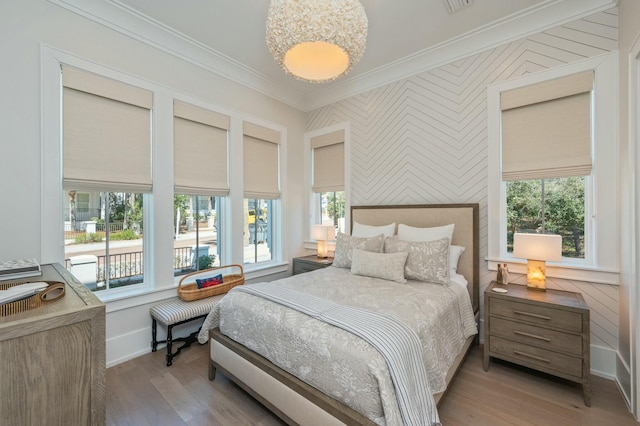 bedroom with crown molding, multiple windows, wood finished floors, and baseboards