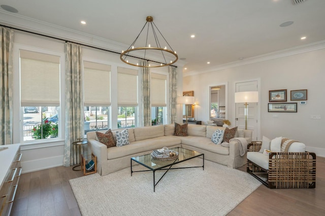 living room featuring a chandelier, crown molding, baseboards, and wood finished floors