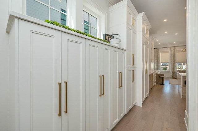 hallway featuring recessed lighting, light wood-style floors, and ornamental molding