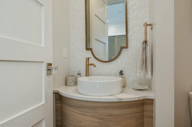 bathroom featuring decorative backsplash, toilet, and vanity