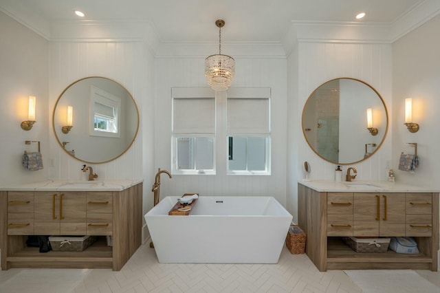 full bath featuring an inviting chandelier, two vanities, crown molding, and a sink