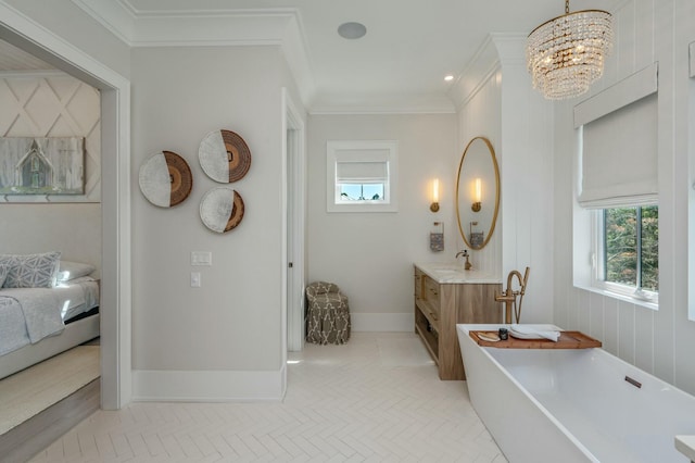 full bathroom featuring baseboards, a chandelier, ornamental molding, a soaking tub, and vanity