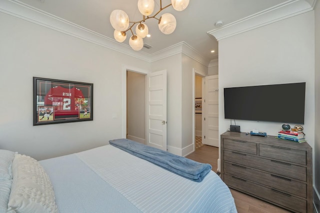 bedroom with visible vents, baseboards, ornamental molding, a notable chandelier, and light wood-type flooring