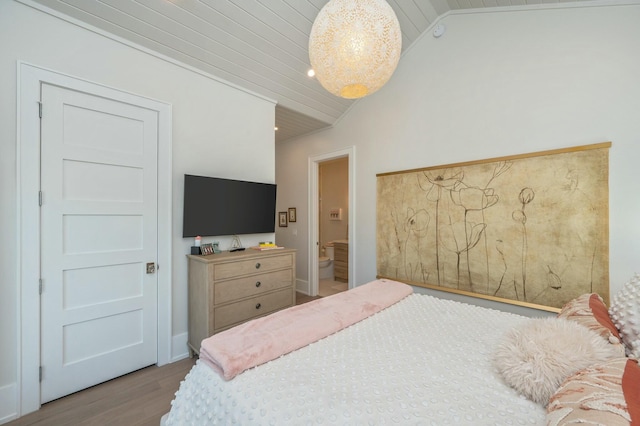 bedroom with wood finished floors and vaulted ceiling