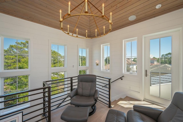 sunroom with an inviting chandelier and wood ceiling