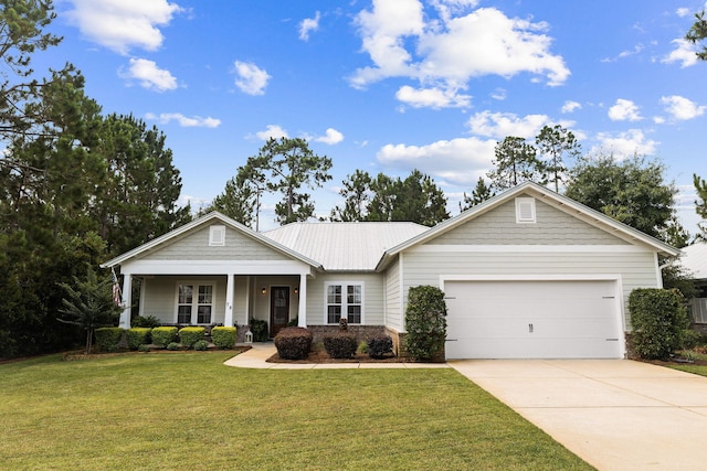 view of front of home featuring a front lawn, a porch, concrete driveway, an attached garage, and metal roof