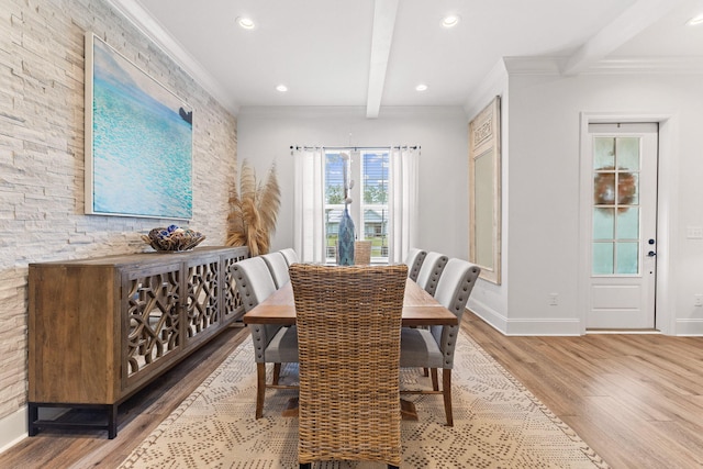 dining space featuring beamed ceiling, baseboards, wood finished floors, and crown molding