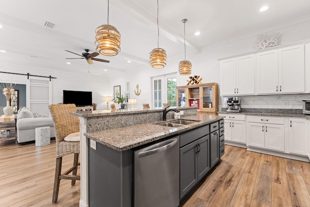 kitchen featuring dishwasher, a ceiling fan, light wood-style floors, and a sink