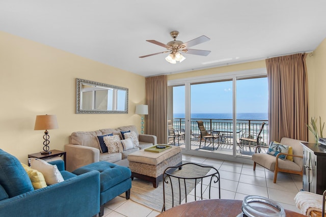 living room featuring light tile patterned flooring, a ceiling fan, and a water view