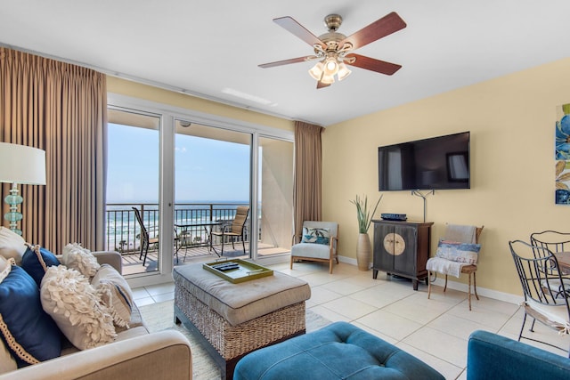 living room featuring tile patterned floors, baseboards, and ceiling fan