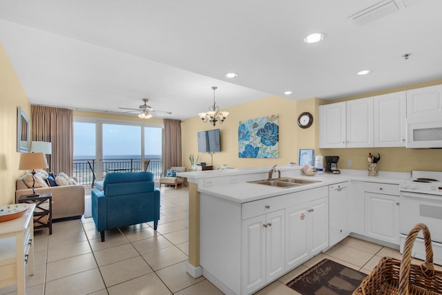 kitchen featuring white appliances, open floor plan, visible vents, and a sink