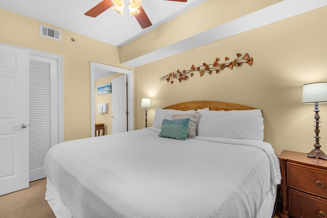 bedroom featuring visible vents, light colored carpet, a closet, and a ceiling fan