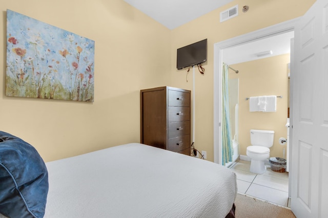 tiled bedroom featuring visible vents and connected bathroom