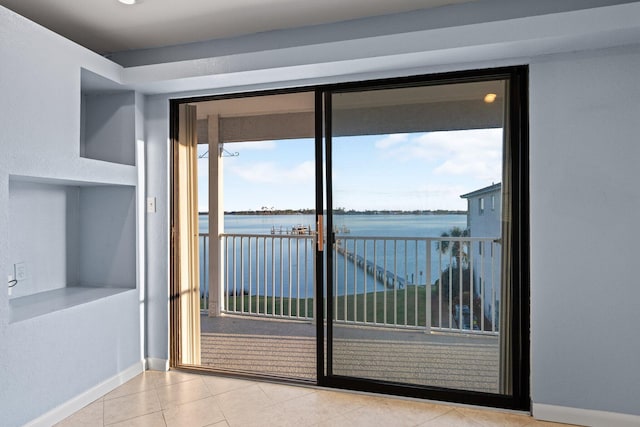 entryway with tile patterned flooring, baseboards, and a water view