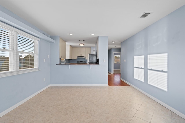 unfurnished living room with recessed lighting, visible vents, and baseboards