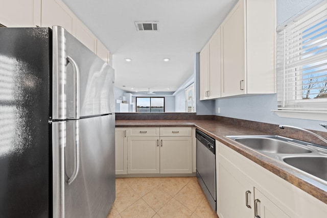 kitchen with visible vents, a sink, dark countertops, stainless steel appliances, and light tile patterned floors