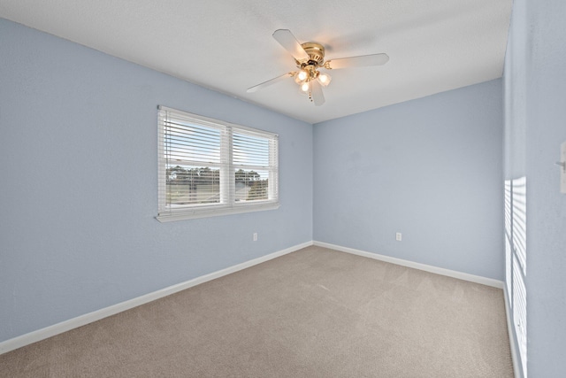 empty room with light carpet, baseboards, and ceiling fan