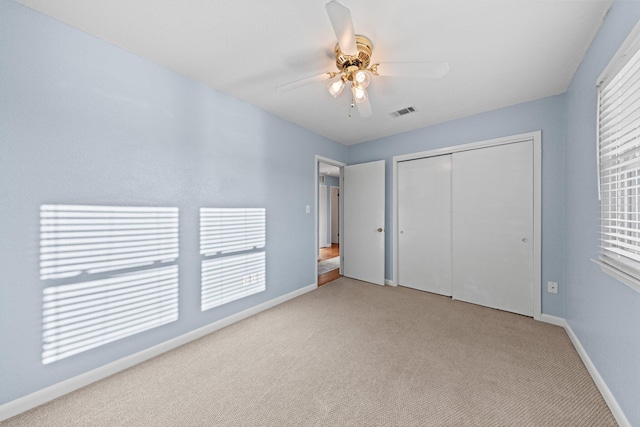 unfurnished bedroom featuring visible vents, baseboards, carpet, a closet, and a ceiling fan