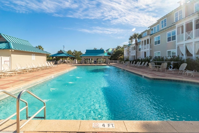 pool with a gazebo, fence, and a patio