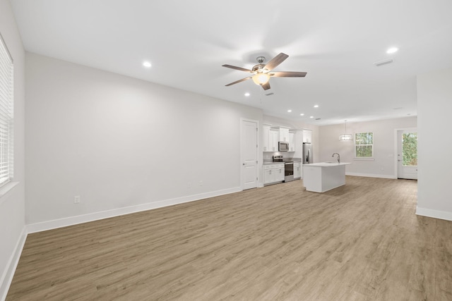 unfurnished living room featuring a ceiling fan, light wood-style floors, recessed lighting, and baseboards