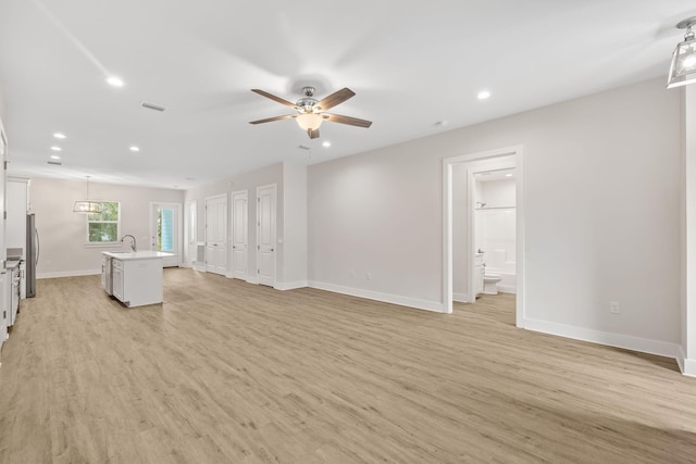 unfurnished living room with a ceiling fan, recessed lighting, light wood-style floors, and baseboards