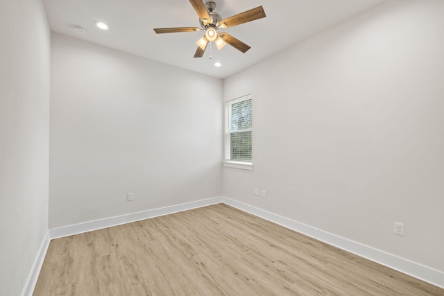 empty room with light wood-type flooring, a ceiling fan, recessed lighting, baseboards, and a smoke detector