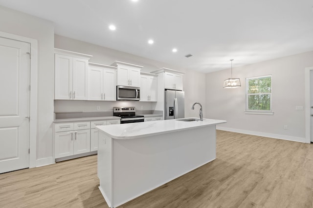 kitchen with appliances with stainless steel finishes, a sink, a center island with sink, white cabinets, and recessed lighting