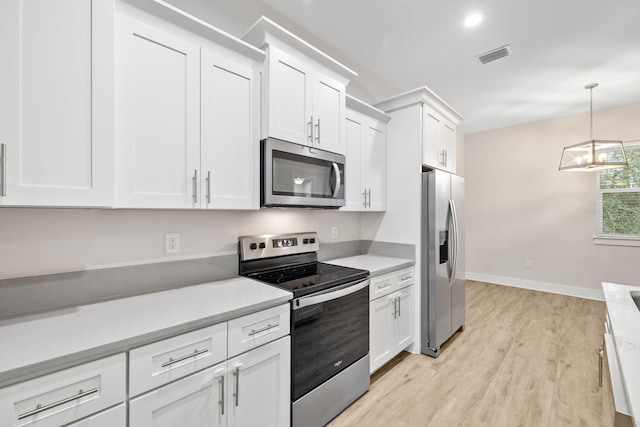 kitchen featuring appliances with stainless steel finishes, light wood-style flooring, white cabinets, and light countertops