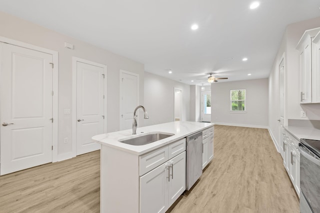 kitchen featuring a sink, stainless steel appliances, light wood-type flooring, white cabinetry, and an island with sink