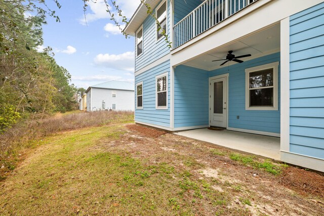 view of yard with a balcony, ceiling fan, and a patio