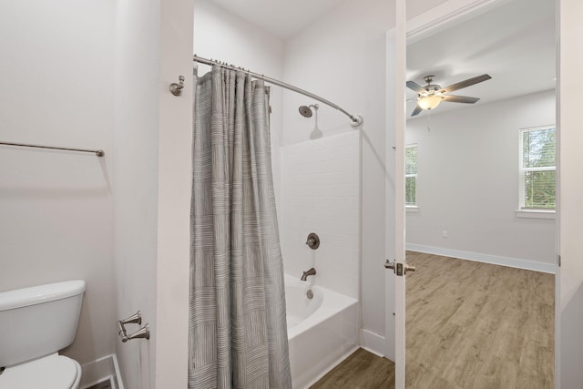 full bathroom featuring wood finished floors, toilet, a ceiling fan, shower / bathtub combination with curtain, and baseboards