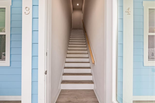 staircase featuring wood finished floors and baseboards