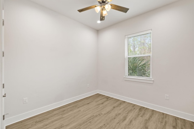 spare room with light wood-style floors, baseboards, and ceiling fan