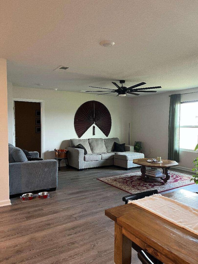 living room featuring a textured ceiling, a ceiling fan, and wood finished floors