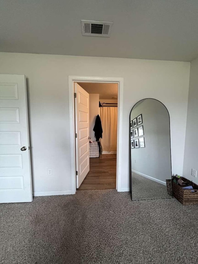 unfurnished bedroom featuring visible vents, baseboards, and carpet