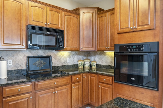 kitchen with black appliances, dark stone countertops, tasteful backsplash, and brown cabinets