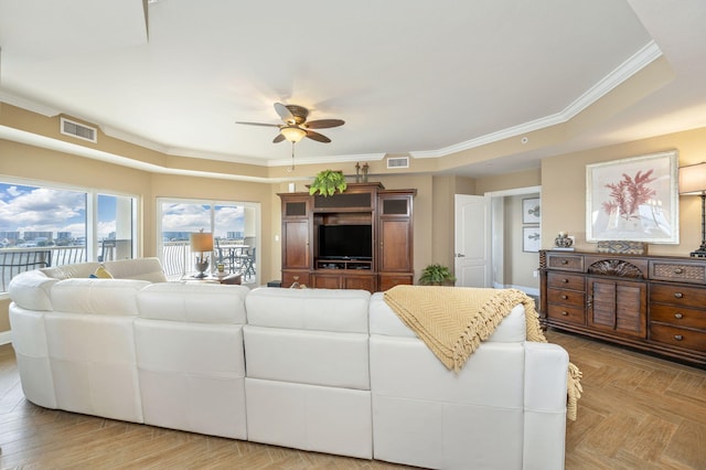 living area featuring visible vents, ceiling fan, and ornamental molding