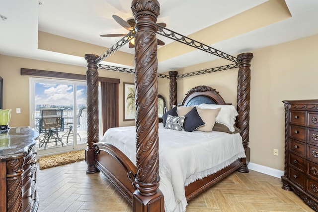 bedroom with a tray ceiling, baseboards, a ceiling fan, and access to outside