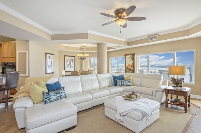 living room featuring visible vents, ceiling fan with notable chandelier, a tray ceiling, crown molding, and baseboards