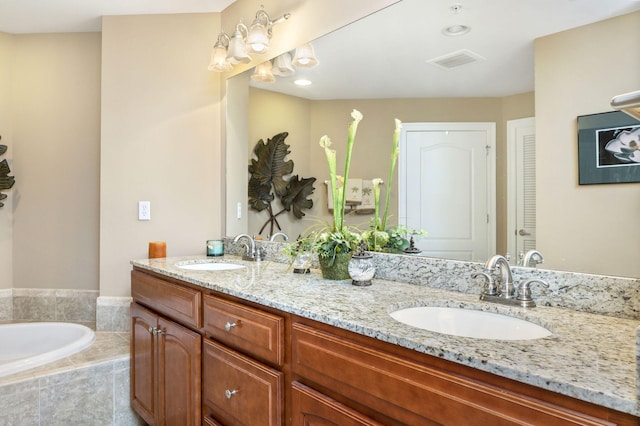 bathroom featuring double vanity, visible vents, a garden tub, and a sink