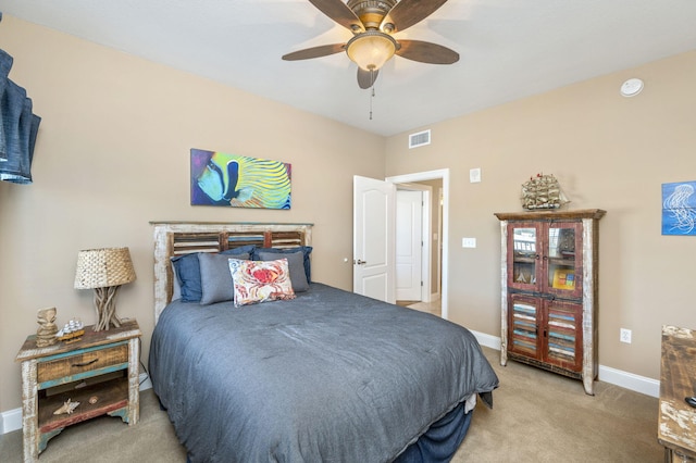 bedroom featuring visible vents, light colored carpet, a ceiling fan, and baseboards