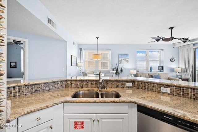 kitchen featuring a ceiling fan, light stone countertops, a sink, white cabinets, and dishwasher