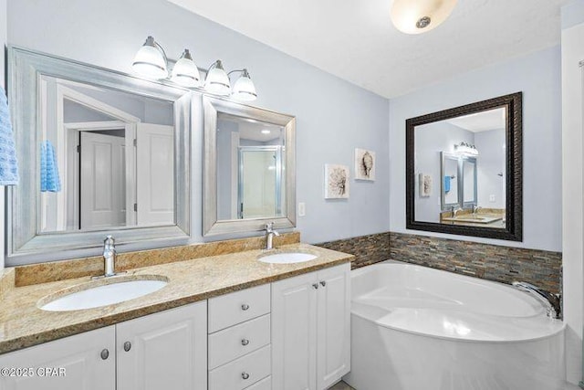 full bathroom with double vanity, a bath, and a sink