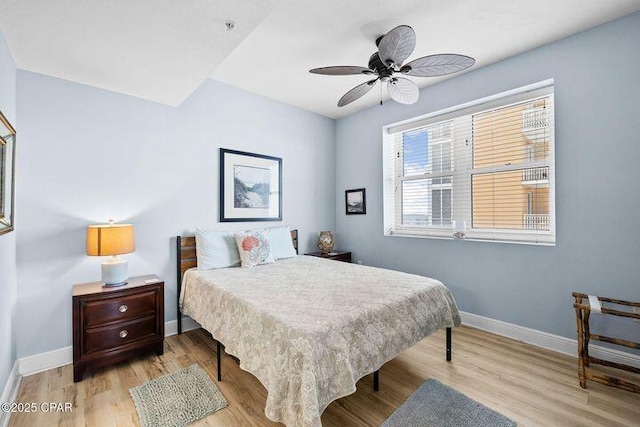 bedroom with ceiling fan, baseboards, and wood finished floors