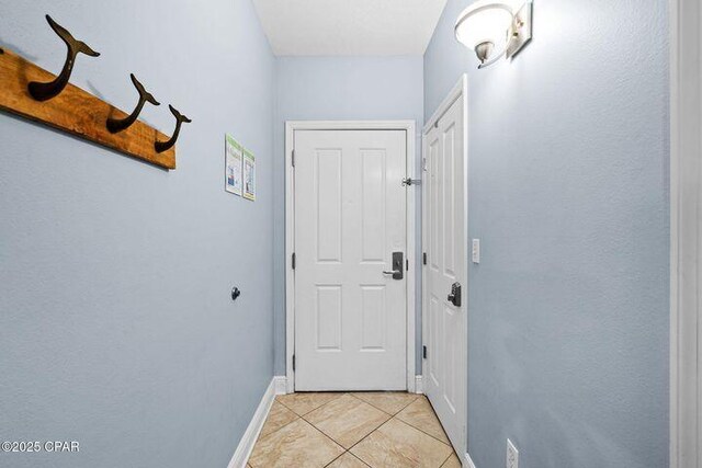 doorway to outside with light tile patterned floors and baseboards