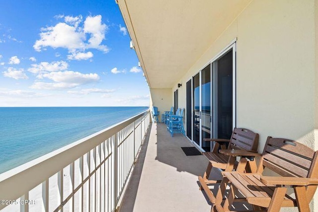 balcony featuring a view of the beach and a water view