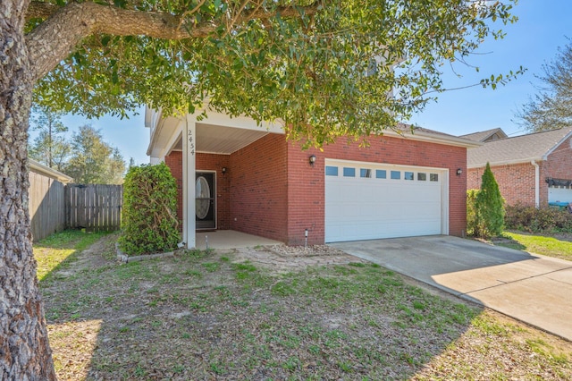 view of front of house with brick siding, concrete driveway, a garage, and fence