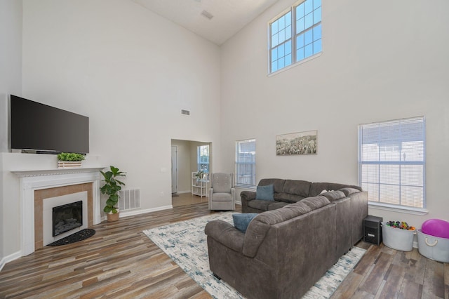 living area with visible vents, plenty of natural light, and wood finished floors